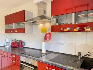 a kitchen with red and white cabinets and a sink at Zimmer & Ferienwohnung Steuer in Leippe +51 photos