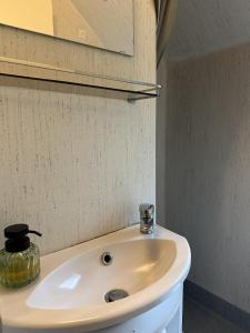 Velling Koller Hotel og Camping في Bryrup: بالوعة بيضاء في الحمام مع مرآة