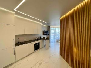a kitchen with white cabinets and a large window at New luxury modern Apartment in Šnipiškės in Vilnius