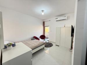 a white room with a bed and a chair at Khalidiya Studio in Abu Dhabi