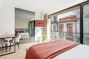 a bedroom with a bed and a large window at GuestReady - Alma Invicta in Porto
