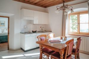 a kitchen with a wooden table and chairs and a dining room at Ansitz Gurtenhof in Tesimo