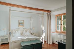 a bedroom with a white canopy bed and a window at Ansitz Gurtenhof in Tesimo