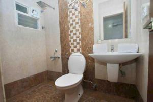 a bathroom with a toilet and a sink at Hotel O Tiruvallur Bus Terminal Formerly SK Vinoth Mahal in Tiruvallūr