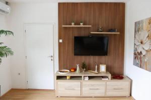 a living room with a tv on a wall at Vikend Kuća Luka in Batrovci
