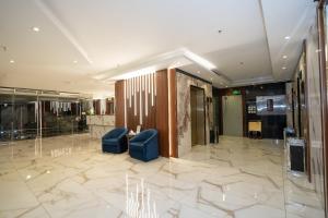 a lobby with two blue chairs in a building at فندق جوهرة المقام الحمراء in Jeddah