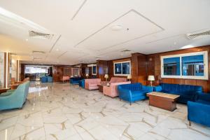 a lobby with blue and pink chairs and tables at فندق جوهرة المقام الحمراء in Jeddah