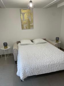 Studio proche de Paris في Valenton: غرفة نوم بها سرير ولوحة على الحائط