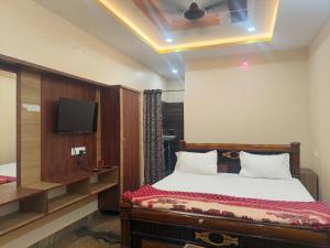 a bedroom with a bed and a flat screen tv at Jaya SriRama Lodge in Bhadrāchalam