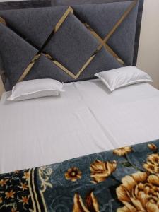 un letto con due cuscini sopra di Radhika P Guest House Ajmer welcome to all family friends groups fully airconditioner attach washroom with geeser near by railway station near by Bus stand less than 1 km a Ajmer Altre 20 foto