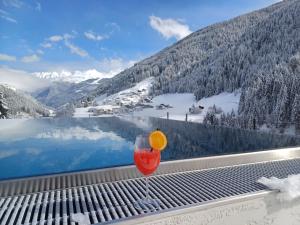 a wine glass sitting on a table with a view of a lake at Hotel Sunshine Superior "ADULTS ONLY" Ischgl - Kappl in Kappl +58 photos