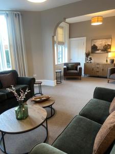 ein Wohnzimmer mit Sofas und einem Tisch und einer Couch in der Unterkunft 4 ABBOTSFORD , KELSO Town Centre in Kelso