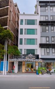 a tall white building with a sign in front of it at Seoul Hotel Cat Ba in Cat Ba +15 photos