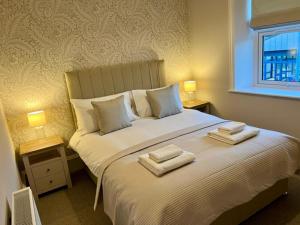 ein Schlafzimmer mit einem großen Bett mit zwei Handtüchern darauf in der Unterkunft 4 ABBOTSFORD , KELSO Town Centre in Kelso + 4 Fotos