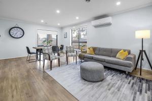a living room with a couch and a table and chairs at Bright & Cozy 4-Bed Home in Rockbank in Rockbank