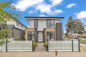 a house with a white picket fence at Bright & Cozy 4-Bed Home in Rockbank in Rockbank