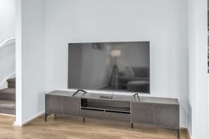 a living room with a flat screen tv on a wall at Bright & Cozy 4-Bed Home in Rockbank in Rockbank