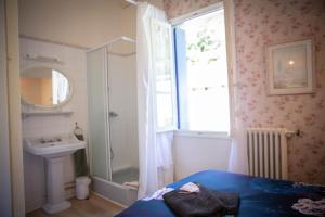 a bathroom with a bed and a shower and a sink at La Roseraie in Lodève +59 photos