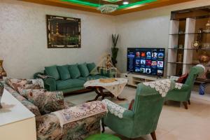 a living room with a green couch and chairs at Apartment Nazaha for families only in Tangier