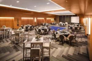 a banquet hall with tables and chairs and a screen at Four Points by Sheraton Mexico City Colonia Roma in Mexico City