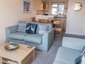 a living room with a blue couch and a table at Daisy Lodge in Norwich +15 photos