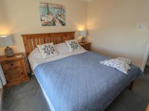 a bedroom with a large blue bed with pillows at Daisy Lodge in Norwich
