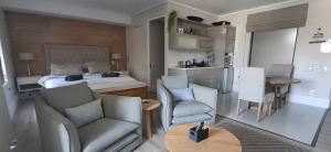 a bedroom with a bed and a table and chairs at The Gallery on Gray in Knysna