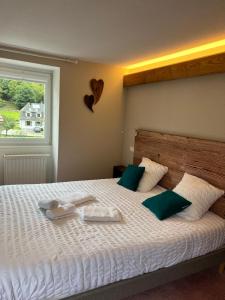 a bedroom with a bed with two towels on it at Hôtel Restaurant Valneige in Mittlach
