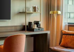 a hotel room with a desk with a coffee maker and a chair at Corendon Amsterdam Schiphol Airport, a Tribute Portfolio Hotel in Badhoevedorp