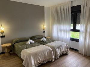 Un dormitorio con una cama con dos toallas encima. en Casa Cancela, en Palas de Rei  20 fotos más