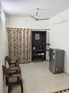 Nitin guest house في جالاندهار: غرفة معيشة مع ثلاجة وكرسي