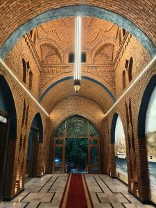 een gang in een bakstenen gebouw met een kroonluchter bij Dahab Now in Dahab +8 foto's