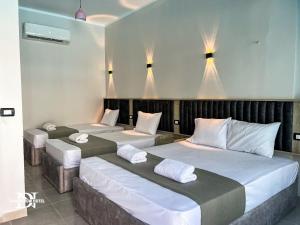 three beds in a room with lights above them at Dahab Now in Dahab +8 photos
