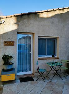 a patio with two chairs and a table and a window at La ruchette in Riez
