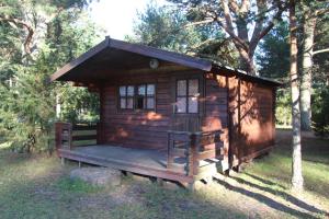 Cabaña de madera pequeña con porche en el césped en Tehumardi Camping en Salme