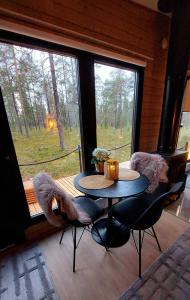 a table and chairs in a room with a window at Lapland Landscape Cabin with Nature View, Sauna, Fireplace & Kitchen, Ylläs, Äkäslompolo, Borealis Village in Äkäslompolo
