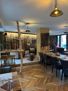 a restaurant with wooden floors and tables and chairs at Hôtel Restaurant Valneige in Mittlach