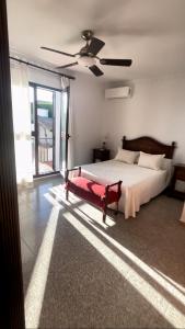 a bedroom with a bed and a large window at Villa Familia in Écija