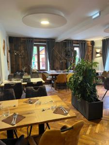 a dining room with wooden tables and chairs and a room with windows at Hôtel Restaurant Valneige in Mittlach