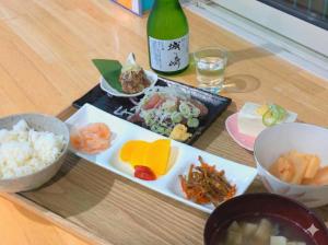 a table with plates of food and a bottle of wine at Villa FUN Kawana in Ito