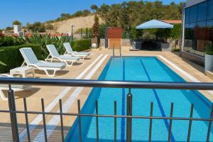 una piscina su un balcone con sedie e ombrellone di Adavilla Elite a Kusadası