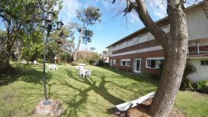 a yard with white tables and a street light and a building at Hostería Bavaria por Las Grullas in Villa Gesell