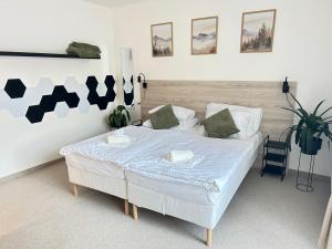 a bedroom with a white bed with a blue comforter at Hotel Sport Houštka  +69 photos