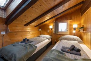 AxalpにあるPeaceful Alpine Home with a View & Hot Tubの木製の壁の部屋にベッドが2つある