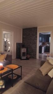 een woonkamer met een bank en een open haard bij Skap Opplevelser! in Svingvoll
