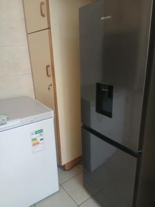 a kitchen with a refrigerator and a small freezer at 16 Laburnum lodge in Durban