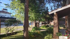 a house with trees and a street in the background at Hostería Bavaria por Las Grullas in Villa Gesell