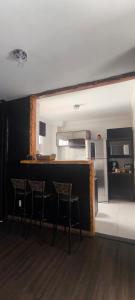 een keuken met een tafel en stoelen en een aanrecht bij Refúgio Premium UTFPR in Londrina