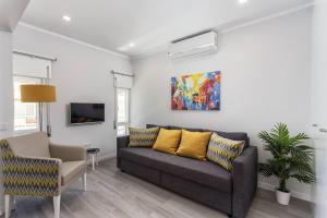 ein Wohnzimmer mit einer Couch und einem Gemälde an der Wand in der Unterkunft Luxury Beach Apartment at Armação de Pêra in Armação de Pêra