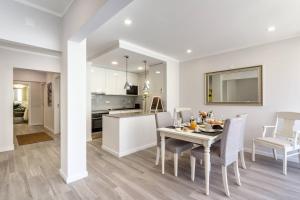 ein Esszimmer und eine Küche mit Tisch und Stühlen in der Unterkunft Luxury Beach Apartment at Armação de Pêra in Armação de Pêra